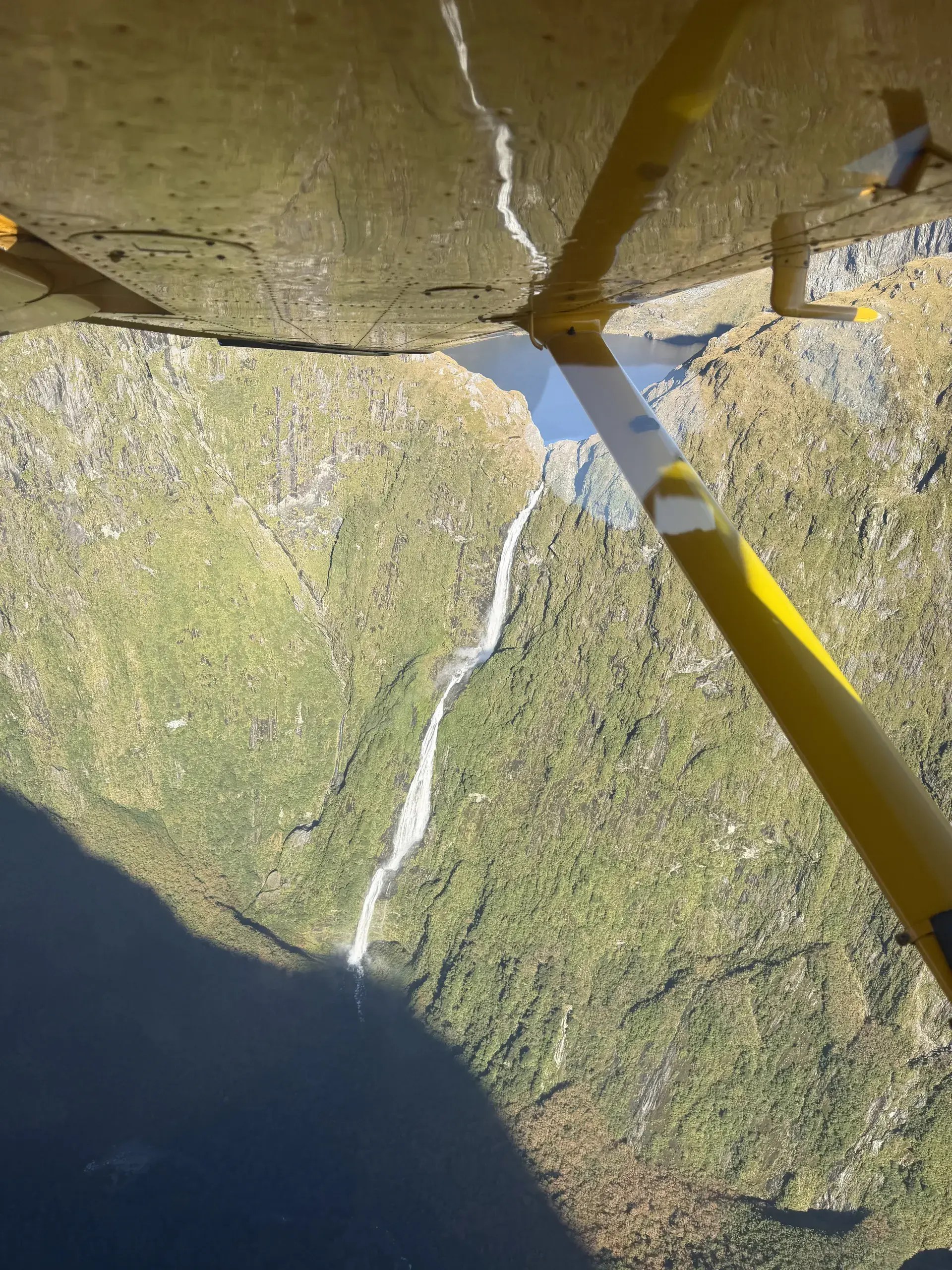 A waterfall dropping into a Fiordland valley from the air